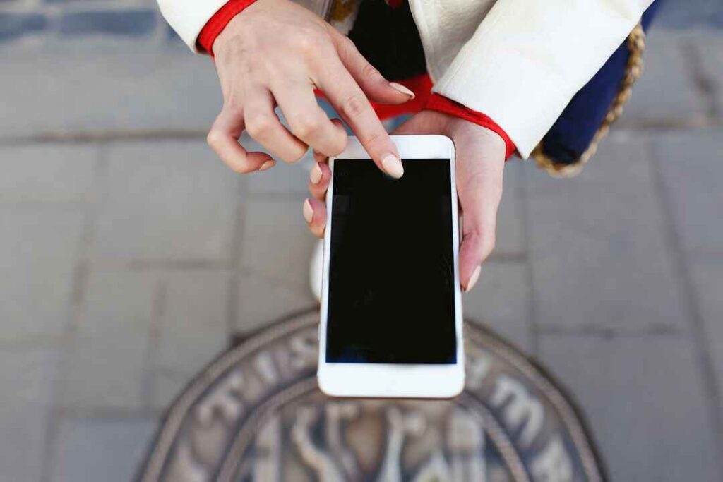 A person holding a phone, demonstrating steps for downloading and installing an OTA update.