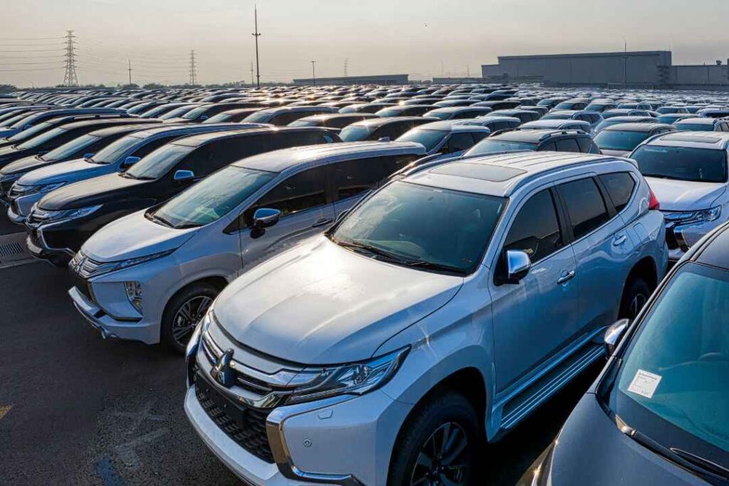 A large fleet of new SUVs parked at an automotive manufacturing facility, representing U.S. auto inventory impacted by rising tariffs and GM's Q2 profit decline.