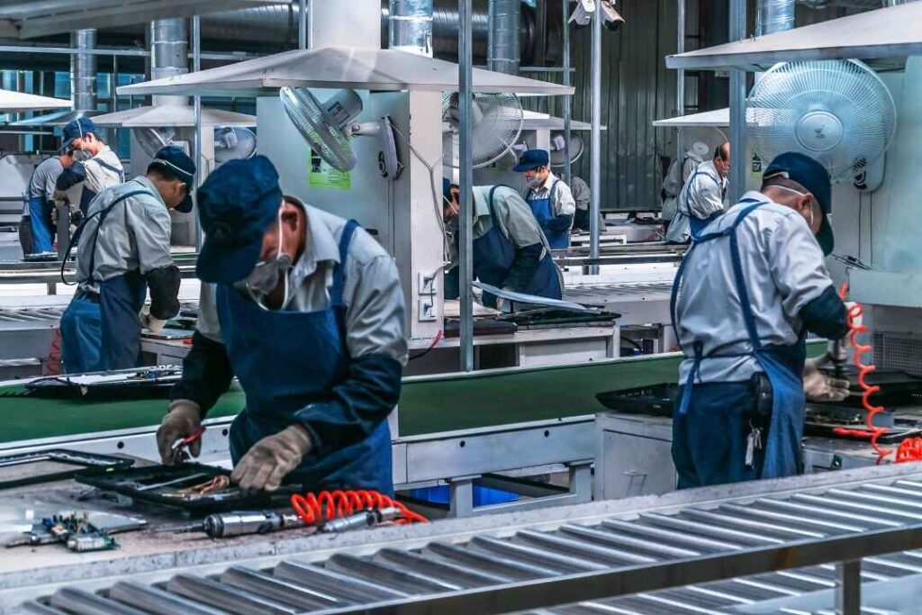 Factory workers operating industrial CNC machining lines in a high-tech manufacturing facility, showcasing precision and automation in modern production.