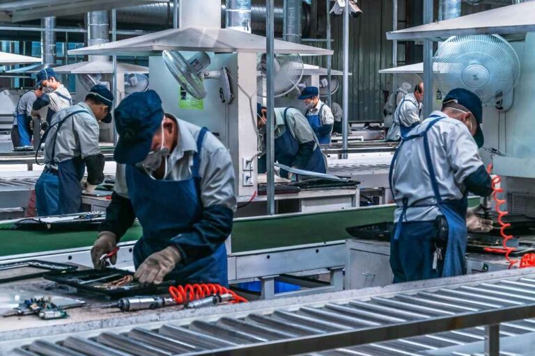 Factory workers operating industrial CNC machining lines in a high-tech manufacturing facility, showcasing precision and automation in modern production.