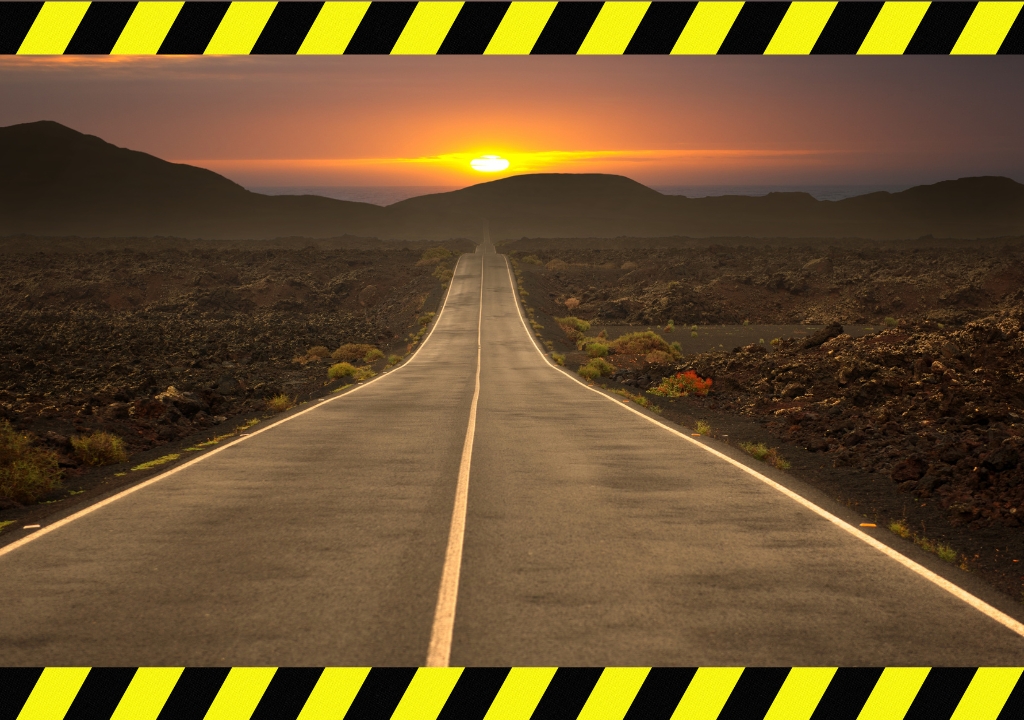 Long empty stretch of the most dangerous highway in the US at sunset with warning tape overlay
