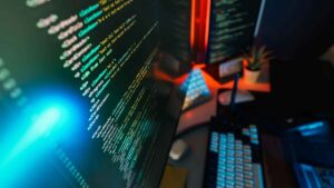 Computer screen displaying colorful code in a cybersecurity setup – concept of how can you prevent viruses and malicious code safely.