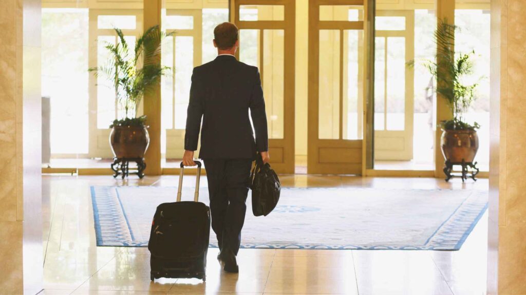 Business traveler arriving at Bages Hotel Barcelona with luggage, symbolizing luxury stay and comfort for modern travelers.
