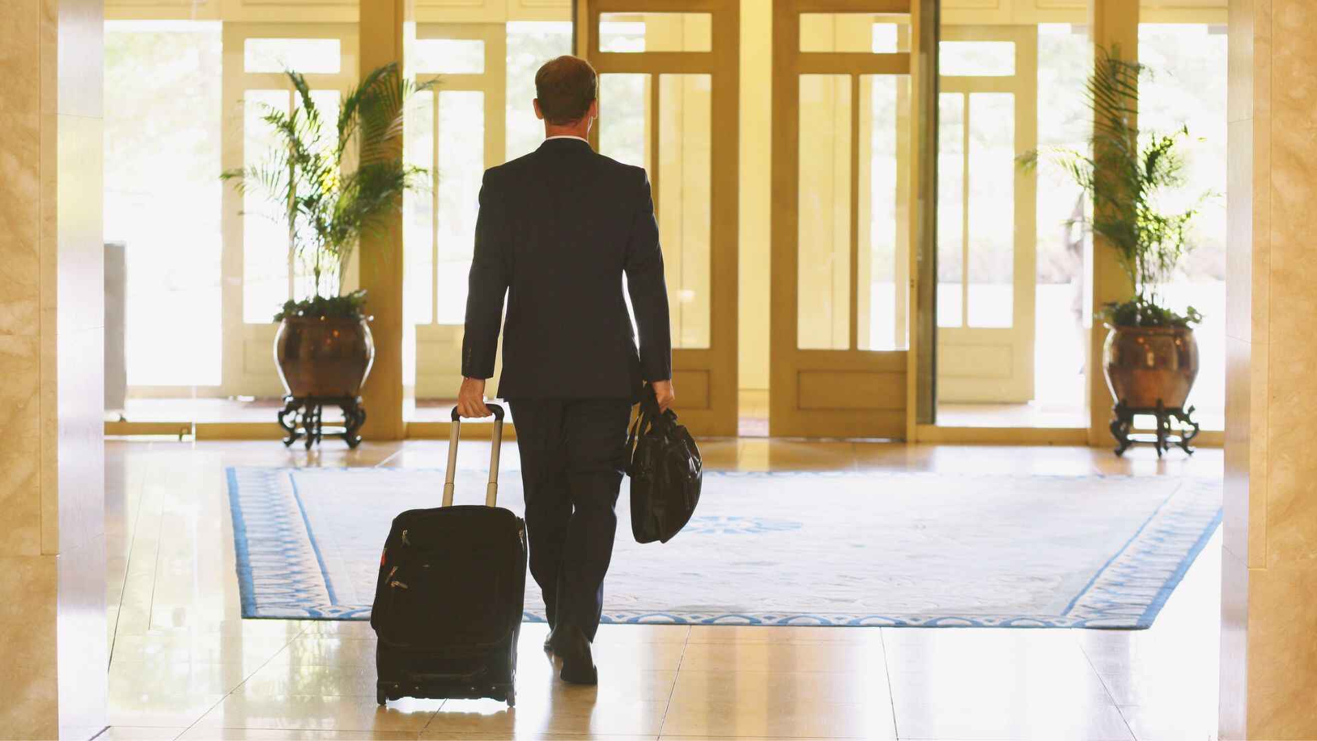 Business traveler arriving at Bages Hotel Barcelona with luggage, symbolizing luxury stay and comfort for modern travelers.