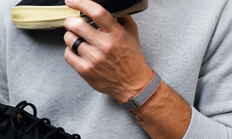 Fitbit Air screenless fitness band worn on wrist with gray performance loop band