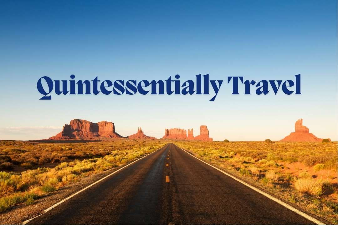 Quintessentially Travel Open road leading to scenic desert landscapes with 'Quintessentially Travel' written in bold, symbolizing luxury bespoke travel services for corporate executives